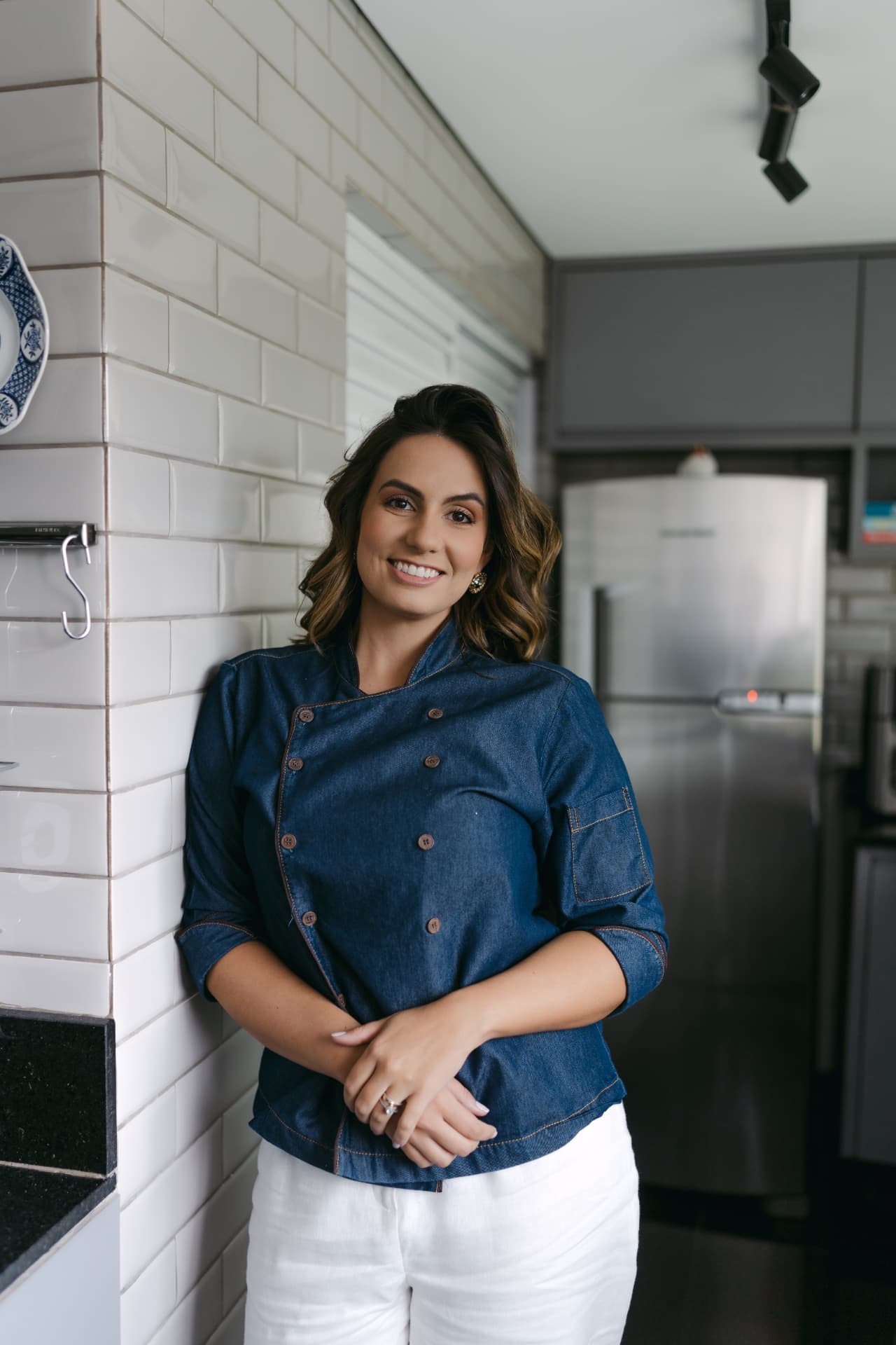 Débora Vasconcelos na cozinha, com dólmã jeans